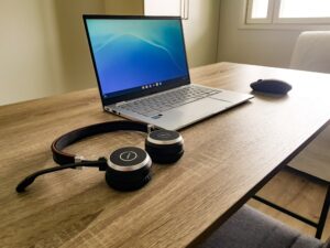 decorative image: a desk with a headset, laptop and a mouse